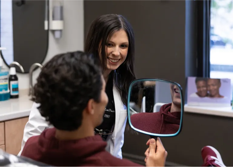Dentist showing a patient their smile in a mirror