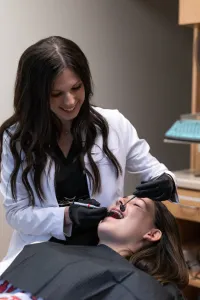 Female dentist examining a patient's teeth in a modern dental clinic.